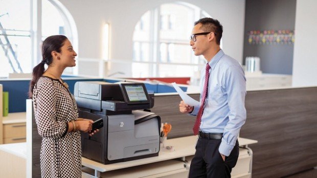 TonerXperts - 5 señales para reemplazar su Impresora - impresora con dos personas platicando